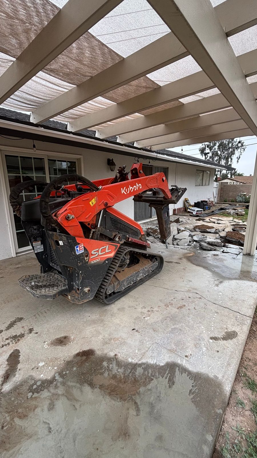 Mini track loader through a narrow side gate